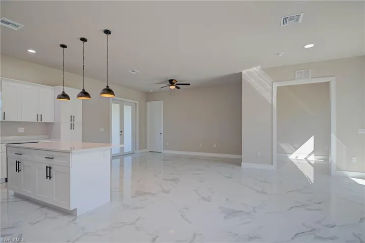 Kitchen with marble finish floor, white cabinetry, and visible vents