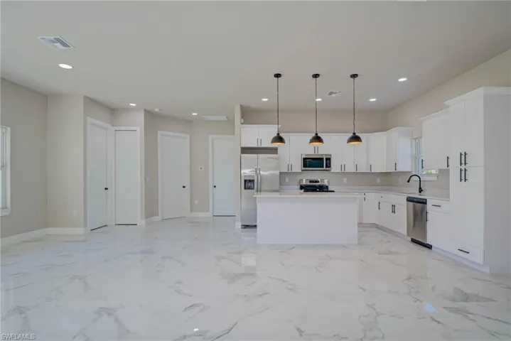 Kitchen featuring light countertops, recessed lighting, stainless steel appliances, a sink, and visible vents