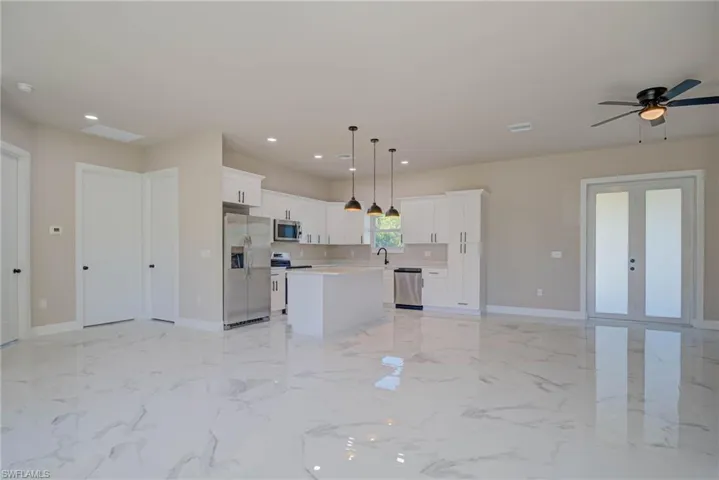 Kitchen with open floor plan, a sink, a kitchen island, and appliances with stainless steel finishes