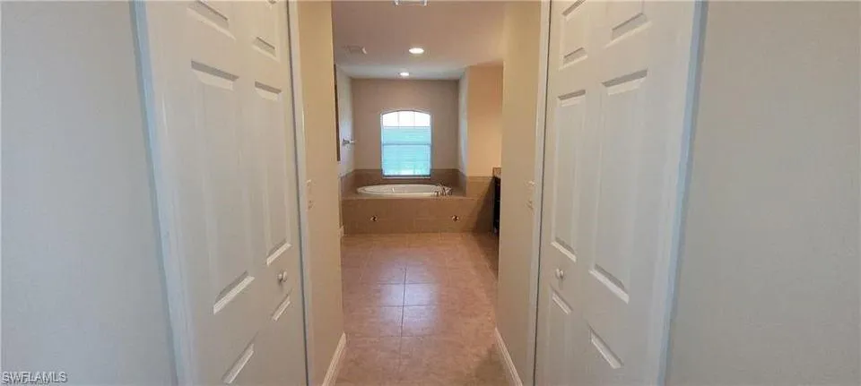 Hall featuring light tile patterned floors