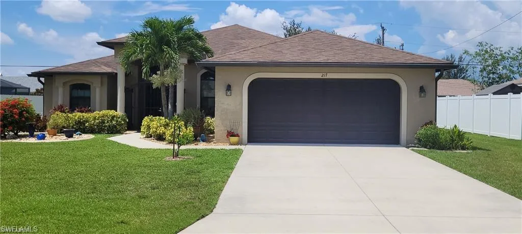 View of front facade featuring a front lawn and a garage