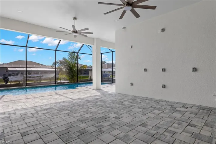 View of swimming pool with a patio area, ceiling fan, and a lanai