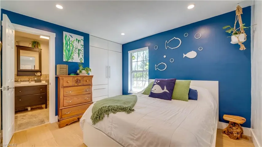 Primary bedroom with laminate flooring, recessed lighting and custom closet.