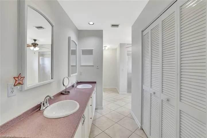 Full bathroom featuring a closet, double vanity, tile patterned floors, and a ceiling fan