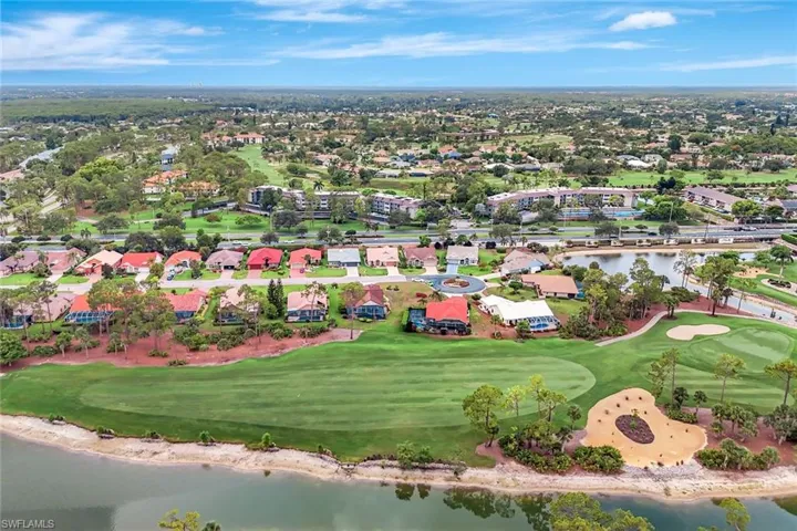 Aerial view of residential area featuring a large body of water and a local golf course