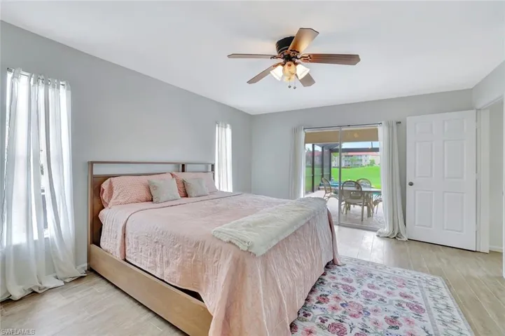 Bedroom featuring access to exterior, light wood-style floors, and ceiling fan