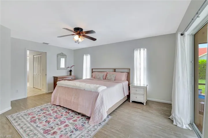 Bedroom with multiple windows, baseboards, and light wood-style floors