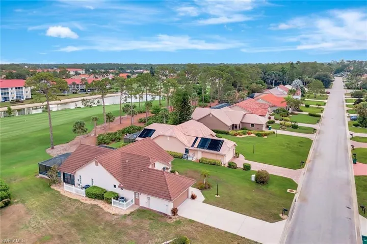 Aerial perspective of suburban area with a nearby body of water and a local golf course