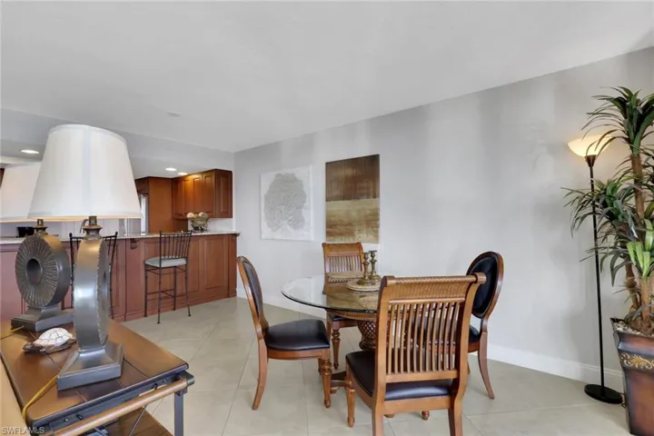 Dining space with light tile patterned floors and recessed lighting
