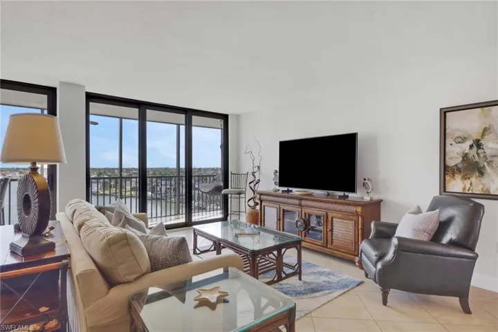 Living room featuring a wall of windows and light tile patterned floors
