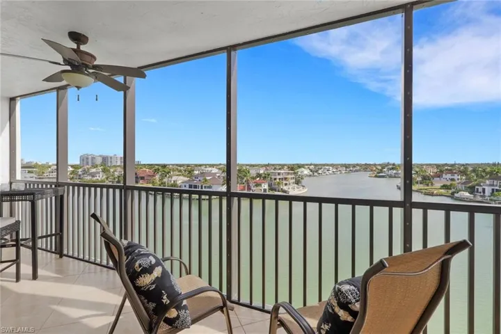 Sunroom / solarium featuring floor to ceiling windows, tile patterned floors, a water view, and a residential view