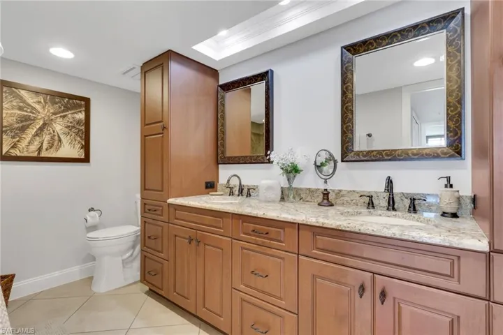 Bathroom with double vanity, recessed lighting, and light tile patterned floors
