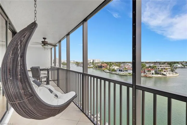 Sunroom with a balcony, a water view, and a ceiling fan