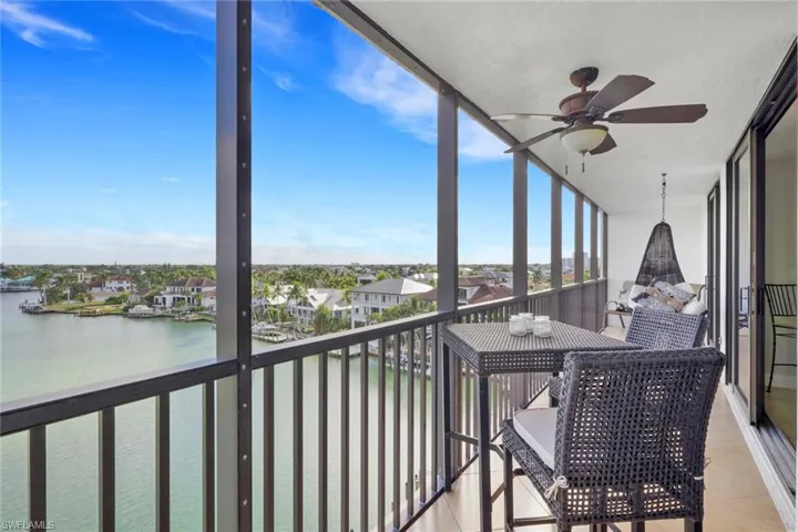 Sunroom featuring floor to ceiling windows, a water view, a residential view, and tile patterned floors