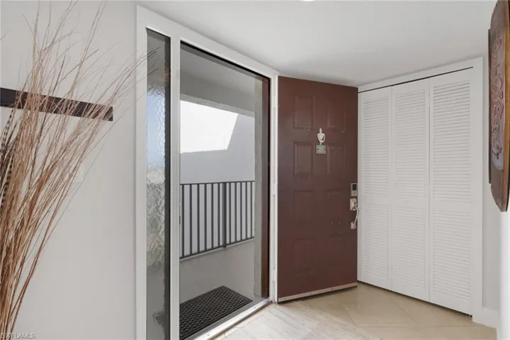 Foyer with light tile patterned flooring