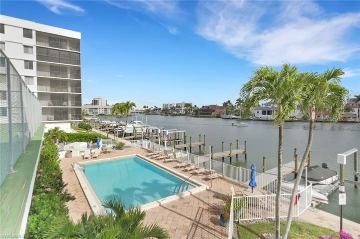 Community pool featuring a boat dock, a water view, boat lift, and a patio area