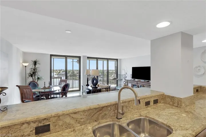 Kitchen with light stone countertops, open floor plan, and recessed lighting