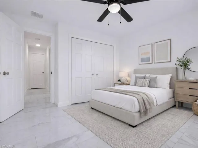 Bedroom with a ceiling fan, a closet, and light marble finish floors