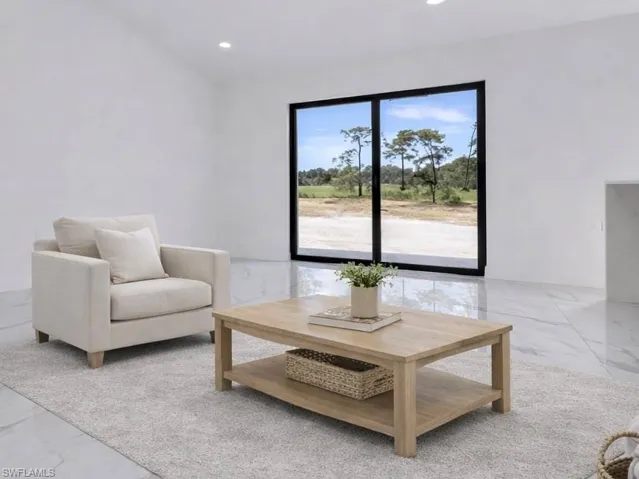 Sitting room with light marble finish floors and recessed lighting