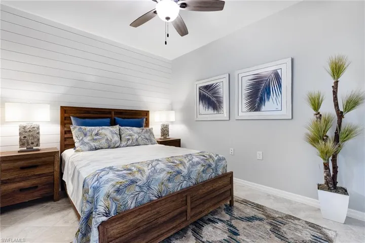 Bedroom featuring ceiling fan and wooden walls