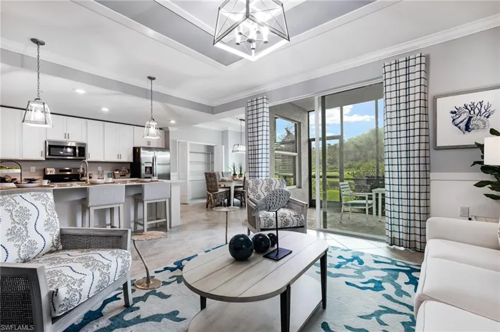 Living area featuring ornamental molding, suspended lighting, and light tile patterned flooring