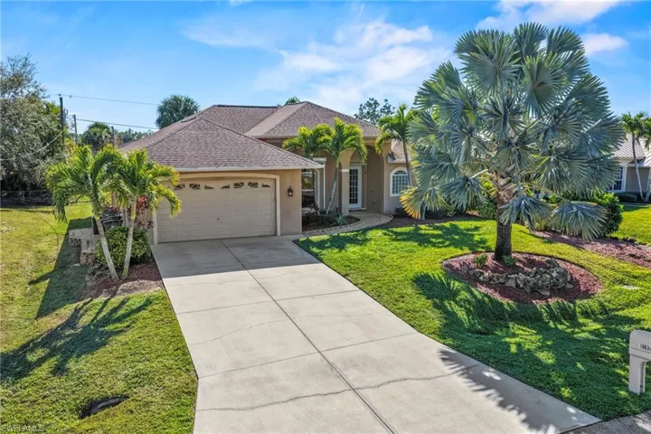 Ranch-style home featuring roof with shingles, a front yard, a garage, stucco siding, and driveway