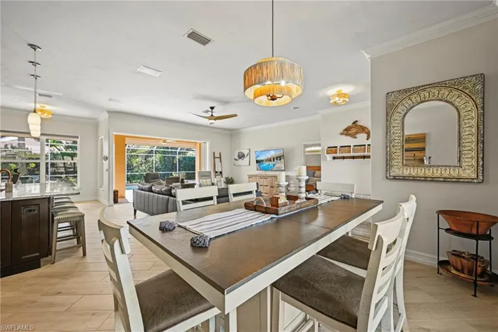 Dining room with ornamental molding, light wood-type flooring, and a ceiling fan