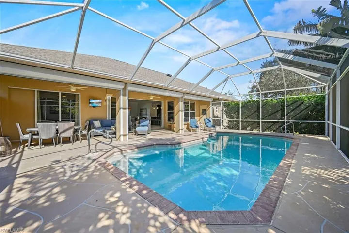 Outdoor pool featuring a sunroom, a patio, glass enclosure, and an outdoor living / dining area