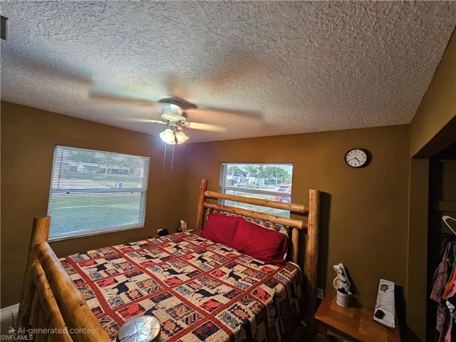 Bedroom with ceiling fan and a textured ceiling