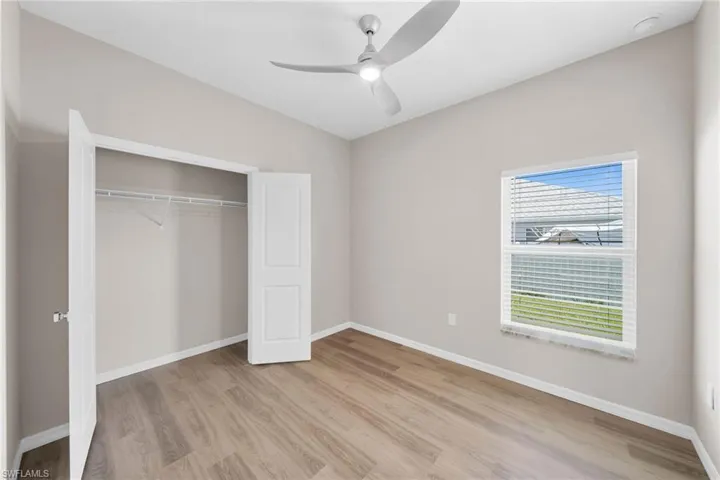 Unfurnished bedroom featuring light wood-type flooring, ceiling fan, and a closet
