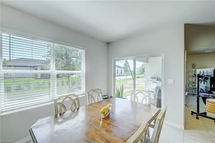 Dining space featuring baseboards, plenty of natural light, and light tile patterned floors