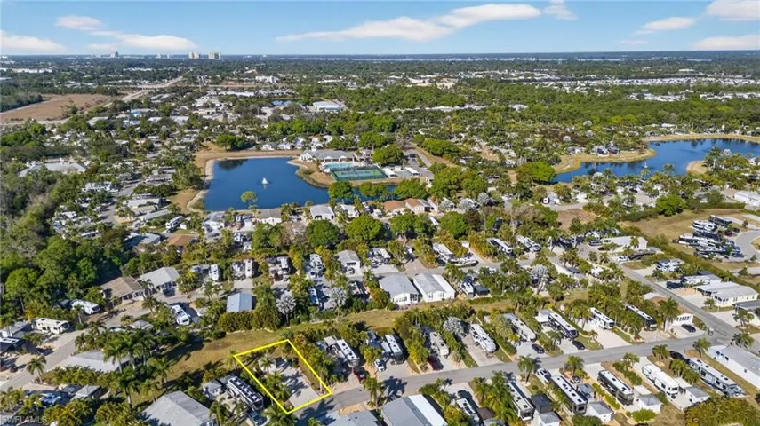 Aerial perspective of suburban area with a large body of water and property boundaries highlighted