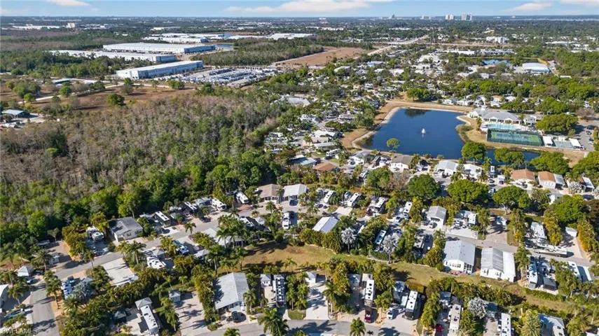 Aerial view of property and surrounding area featuring nearby suburban area and a nearby body of water