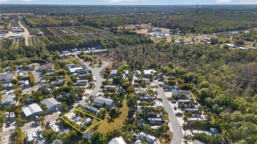 Aerial overview of property's location with property parcel outlined and nearby suburban area