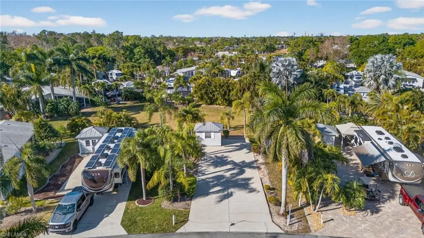 Aerial view of property and surrounding area featuring a tree filled landscape