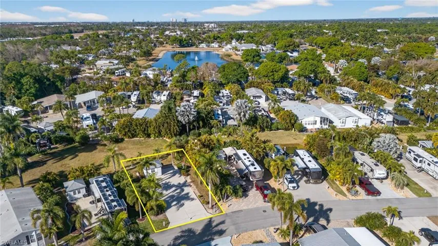 Aerial perspective of suburban area featuring property parcel outlined and a nearby body of water