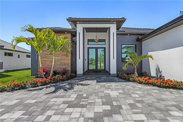 Entrance to property with central air condition unit, french doors, and stucco siding