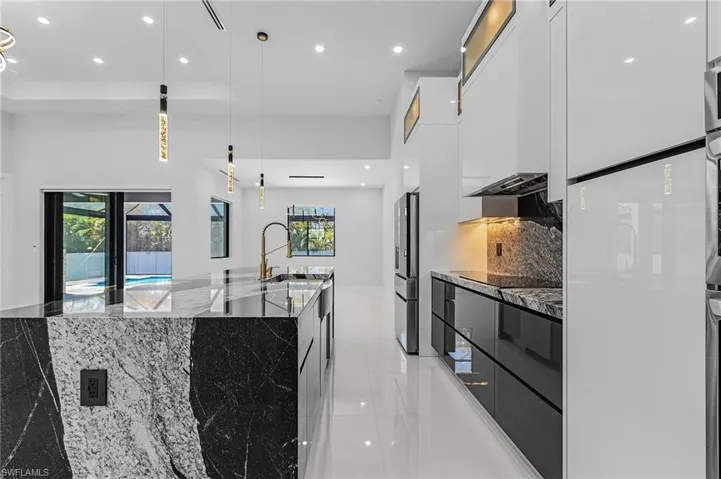 Kitchen featuring white cabinetry, modern cabinets, stainless steel refrigerator with ice dispenser, and a sink