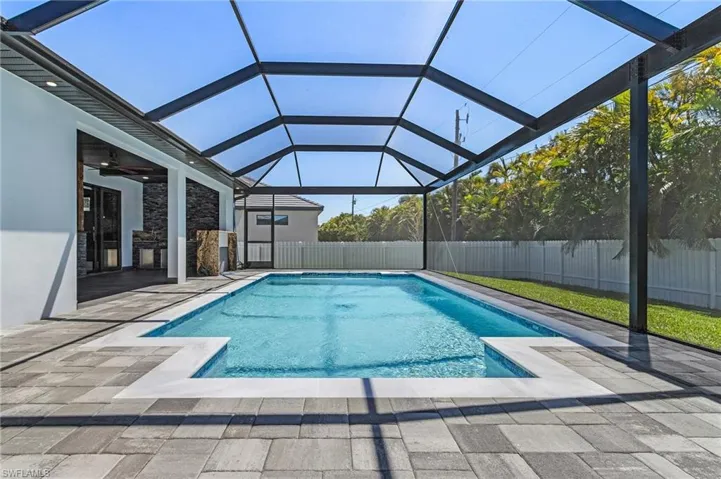 View of swimming pool featuring a fenced in pool, a fenced backyard, glass enclosure, and a patio area