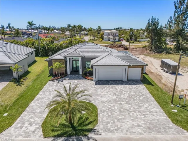 Single story home featuring stucco siding, a tile roof, decorative driveway, a front yard, and an attached garage