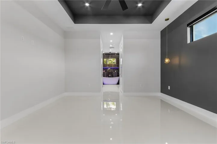 Spare room with tile patterned floors, recessed lighting, baseboards, and a tray ceiling