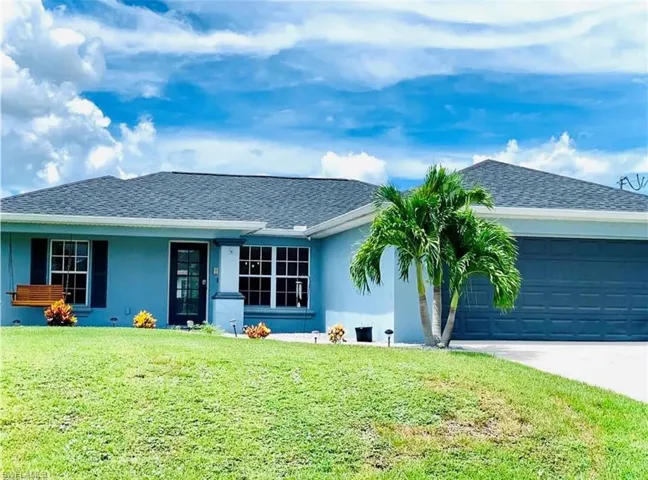 Ranch-style home with stucco siding, a front lawn, driveway, roof with shingles, and a garage