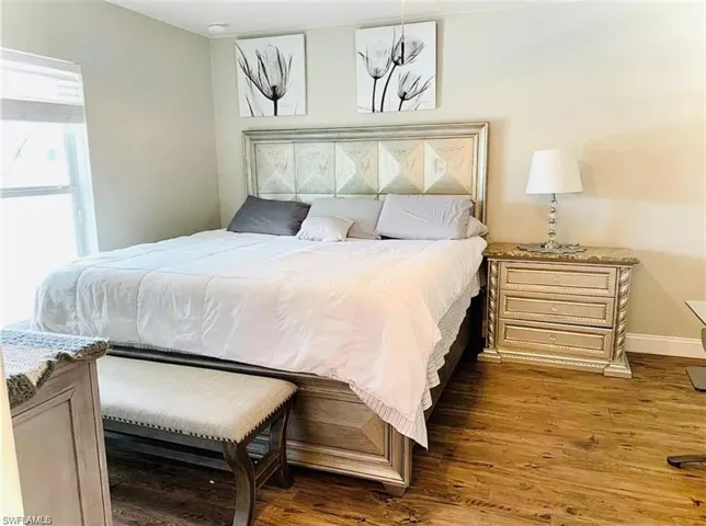 Bedroom with wood finished floors and baseboards