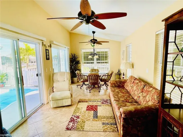 Sunroom / solarium with lofted ceiling, tile patterned floors, and plenty of natural light