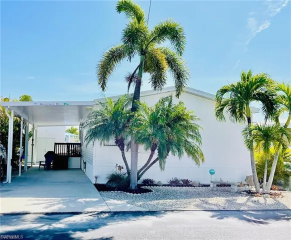 View of front facade featuring an attached carport and driveway