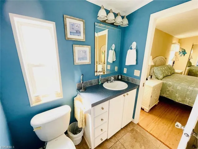 Half bath with vanity, light tile patterned floors, and ensuite bathroom