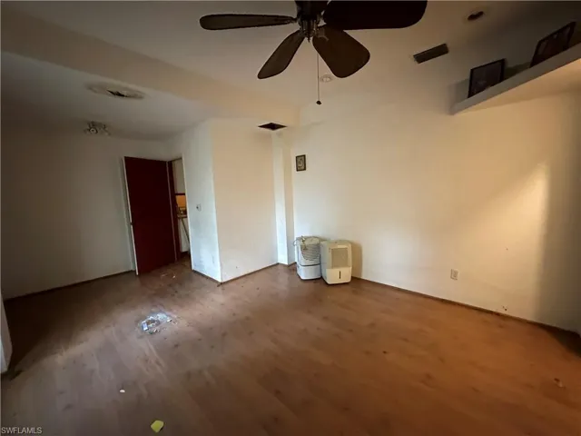 Downstairs, Unfurnished bedroom featuring wood-type flooring and ceiling fan