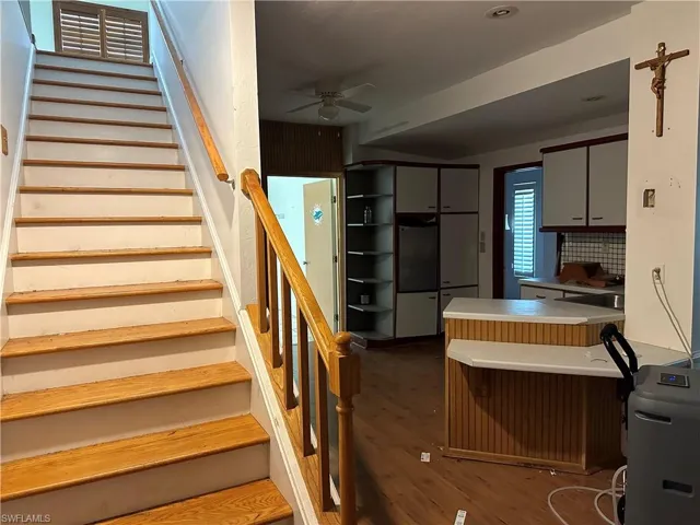 Stairs with ceiling fan and hardwood / wood-style flooring