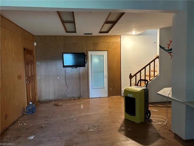 Foyer entrance Downstairs featuring wood walls and hardwood / wood-style floors