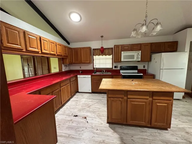 Kitchen Island with light hardwood / wood-style flooring, plenty of natural light, and white appliances